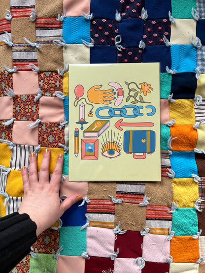 Nomad Print on a colorful quilted background. A hand reaches towards the print to demonstrate scale and sizing.