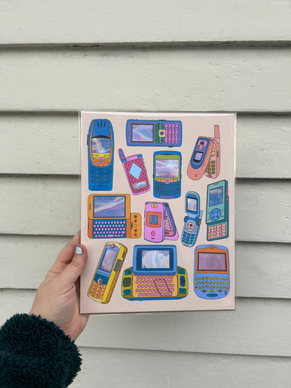 A hand holds a print enclosed in a clear plastic sleeve over a white background. The print image is as follows; 12 outdated cell phones from before the smartphone revolution float above a light ochre colored background. All of the phones have bold and bright color schemes. Four of them are flip phones and three of them slide to reveal buttons and/or keyboards. All of the screens of the phones display a reflective water-like image.