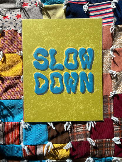 Slow Down print on a colorful quilted background. 